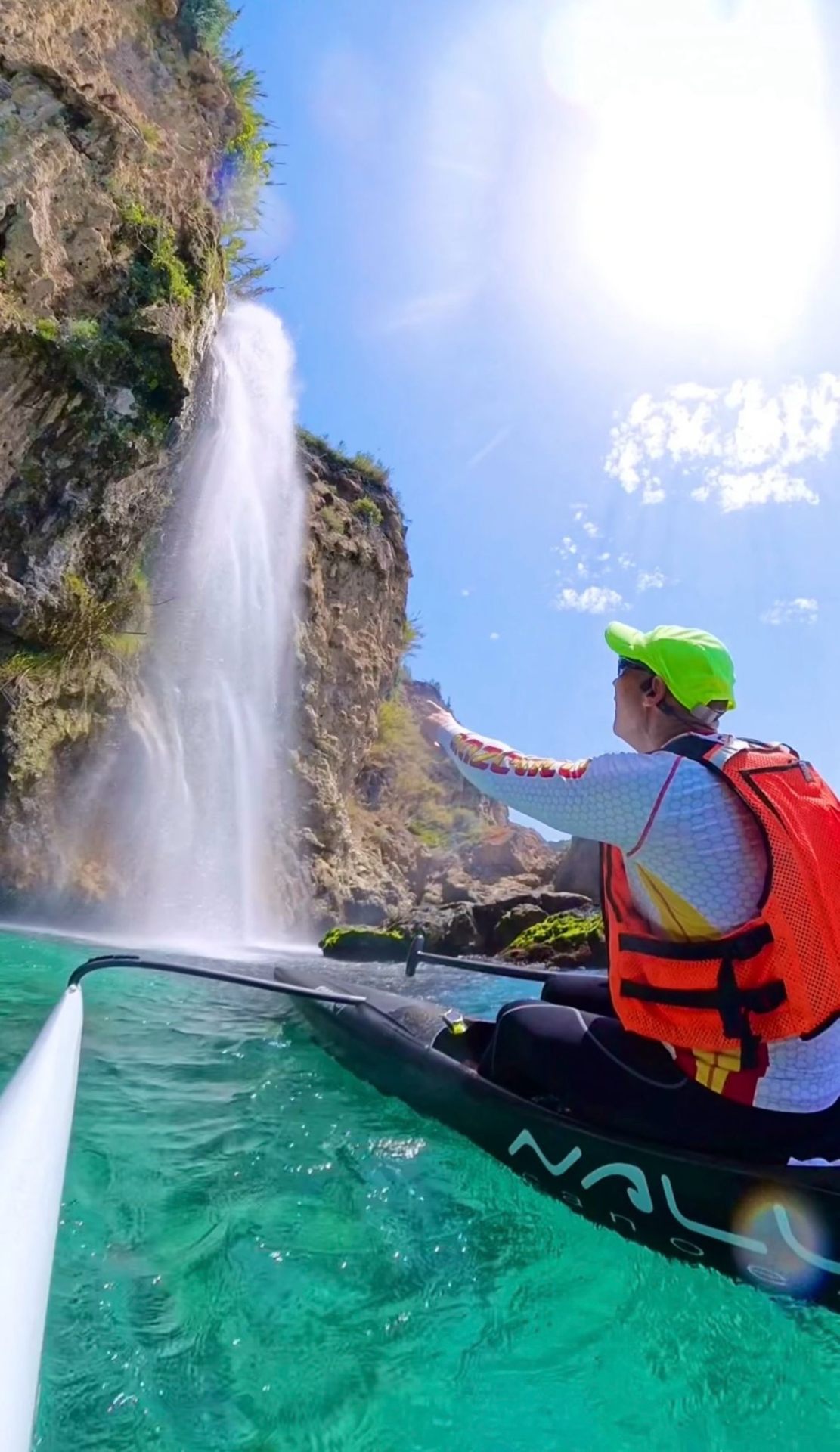 Kayak junto a una cascada en aguas turquesas